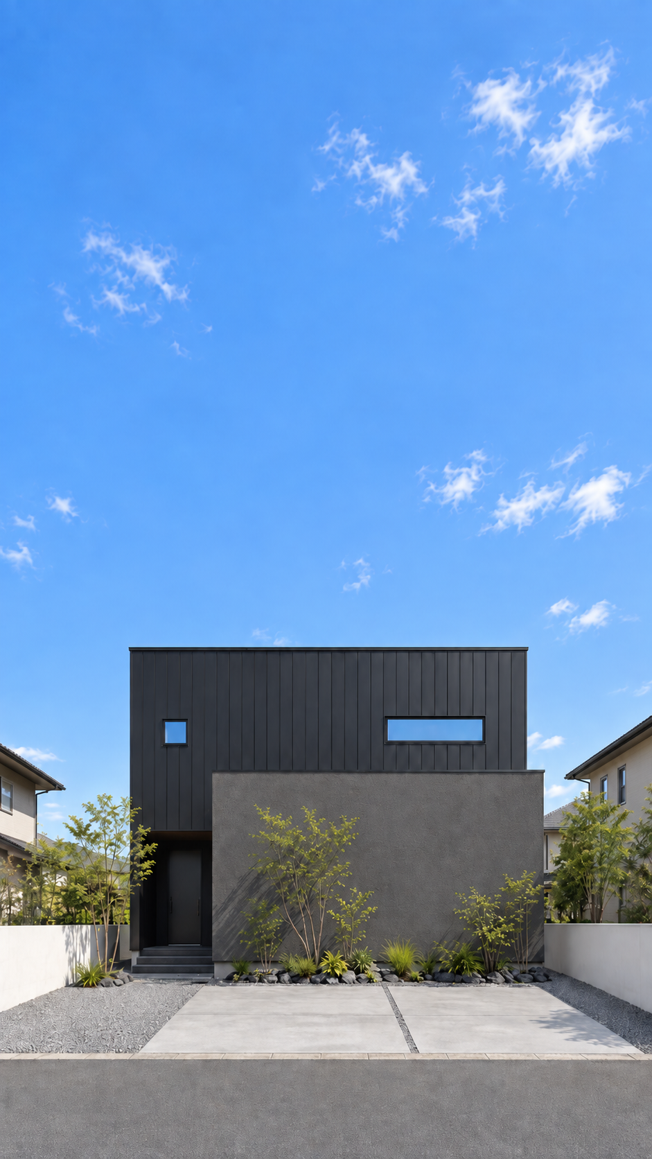 青空の下に建つ、植栽に囲まれたモダンな住まい